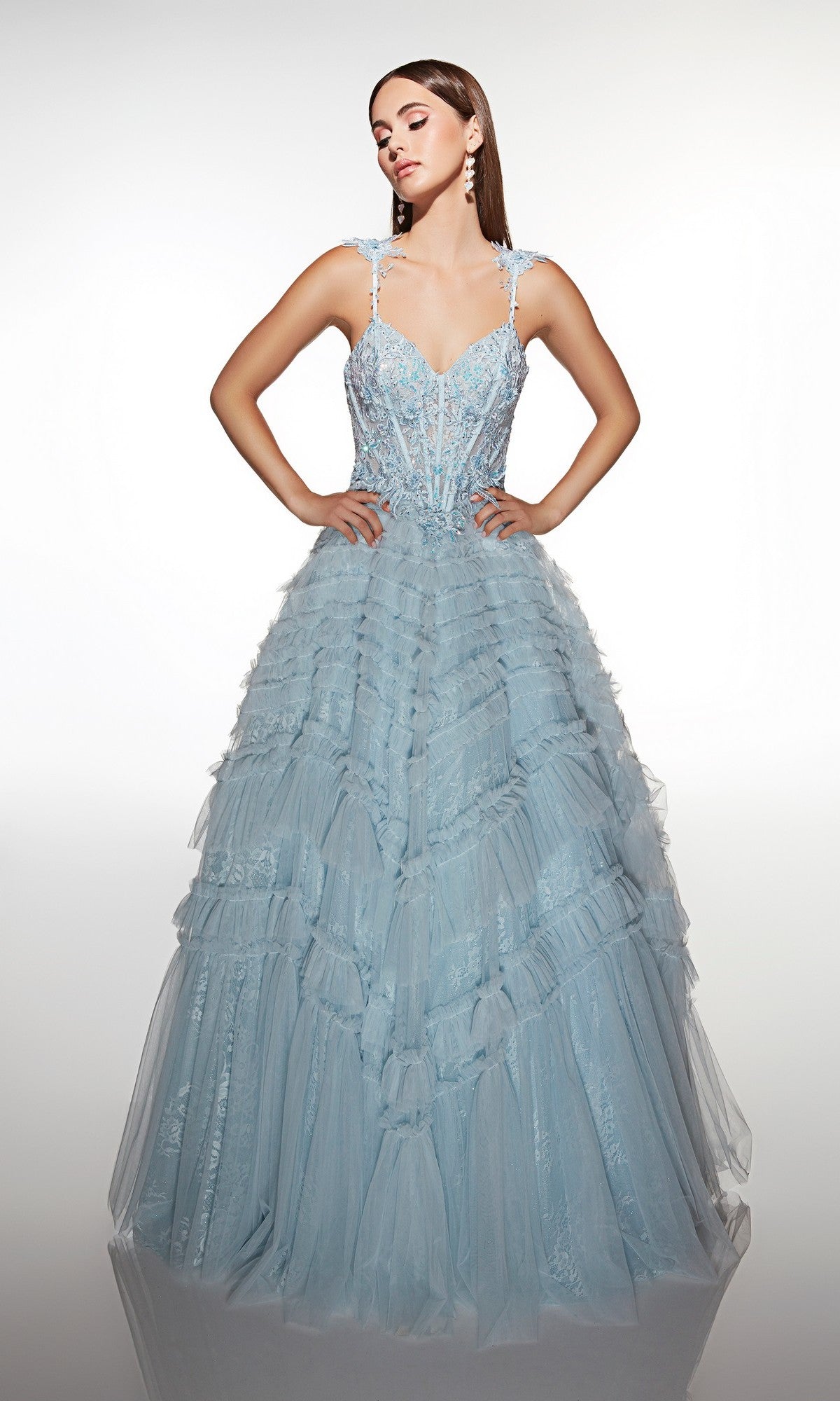 A woman stands with hands on hips against a plain background, wearing the Alyce 62058 long formal dress in sky blue, featuring a lace bodice and layered tulle skirt.